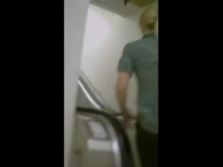 Cativante cu em um escalator em ioga calças