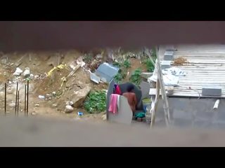 Indian woman bathing outdoors